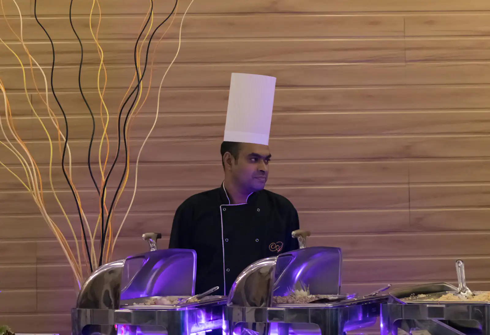 Chef behind hotel buffet equipment serving station showing NKC display equipment